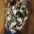 Person wearing a shirt with a tropical bird pattern in an indoor setting